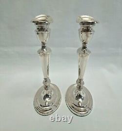 An eight inch pair of vintage sterling silver candlesticks by D. J silver, London