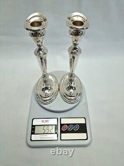 An eight inch pair of vintage sterling silver candlesticks by D. J silver, London